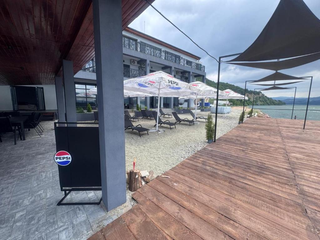 a building with chairs and umbrellas on a beach at Pensiunea EUPHORIA in Sviniţa