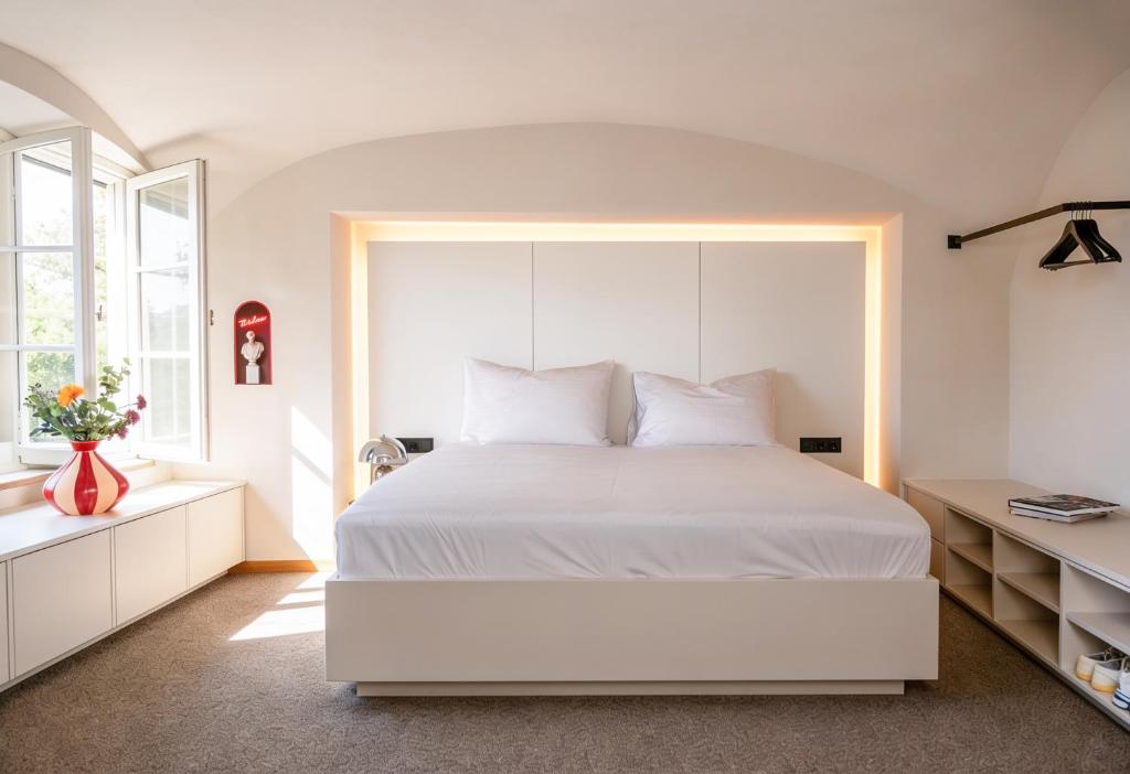 a bedroom with a large white bed and a window at stay micro Regensburg in Regensburg
