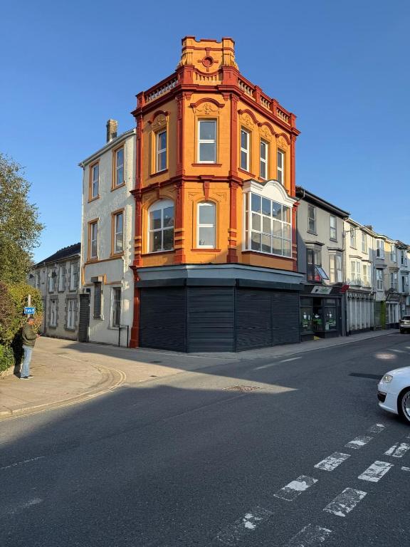 an orange building on the side of a street at Sunny Cottage in Camborne