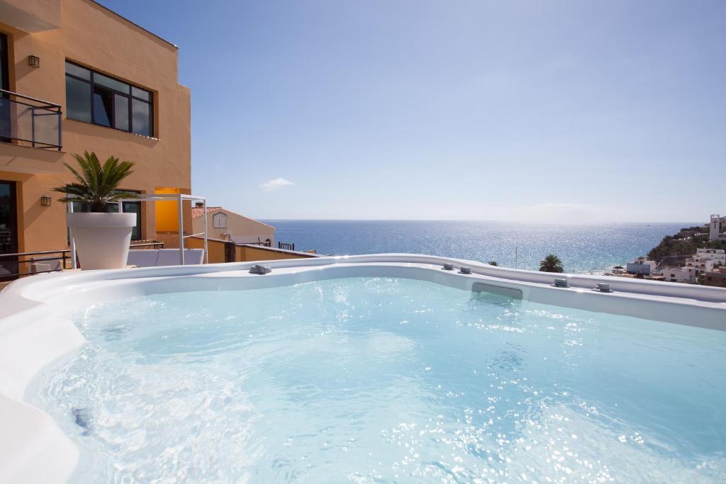 a large swimming pool with a view of the ocean at Villamar Hotel in Morro del Jable