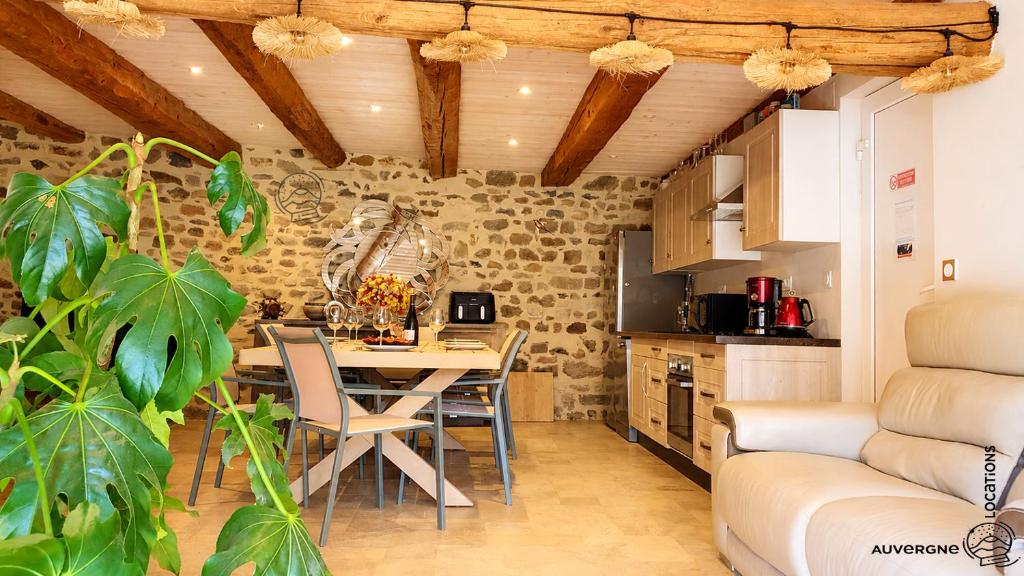 a kitchen with a table and chairs in a room at L'Hirondelle des Sarments in Montaigut-le-Blanc