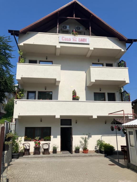 a white building with a sign on it at Casa BABI in Căciulata
