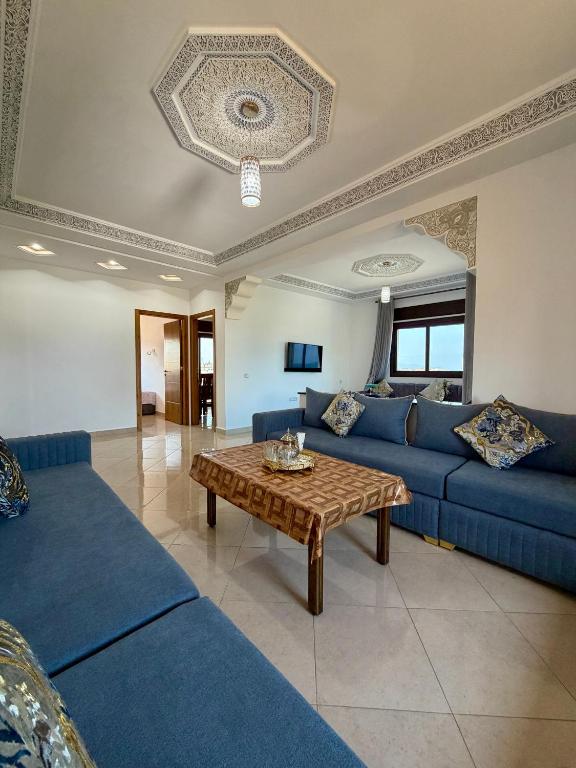a living room with blue couches and a coffee table at Paraiso Costero Azla Tetouan in Azla
