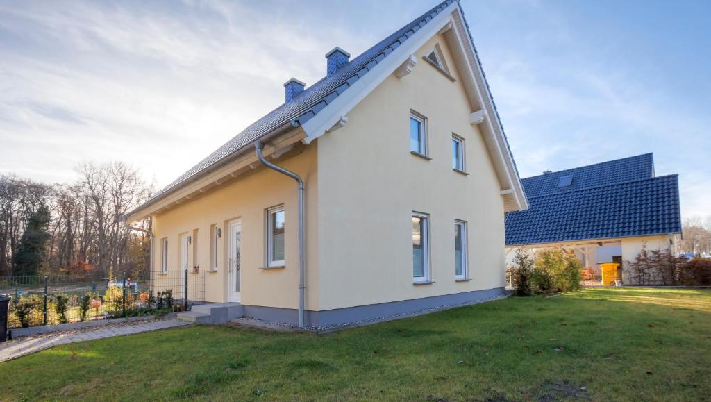 ein kleines weißes Haus mit einem großen Hof in der Unterkunft Haus Störtebeker in Ückeritz