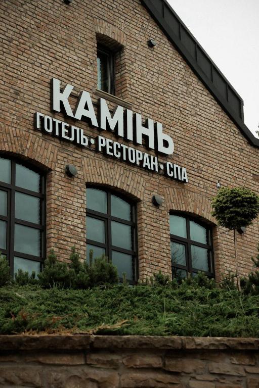 a sign on the side of a brick building at Камінь in Ostrovets