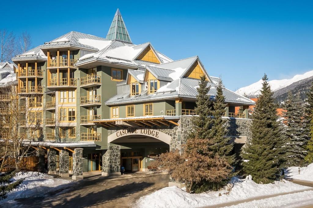 a large building with a snow covered roof at Cascade Lodge Studio-steps from village in Whistler