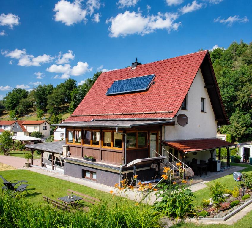 a house with a solar panel on the roof at Ferienwohnung Bamberger mit Wintergarten Schmalkalden in Schmalkalden