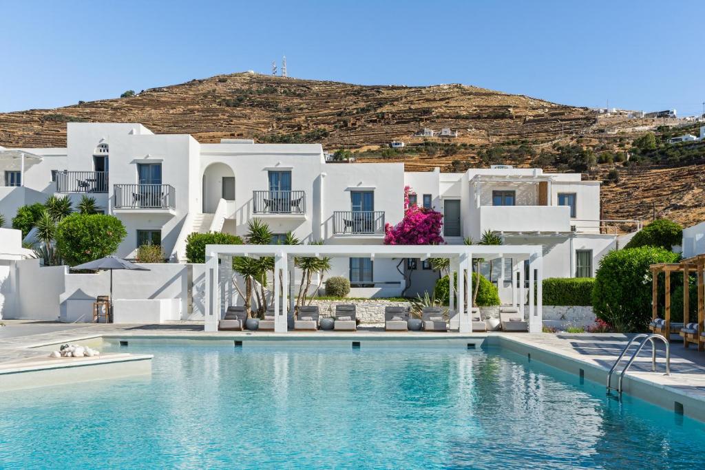 a hotel with a swimming pool in front of white buildings at Mr and Mrs White Tinos in Tinos