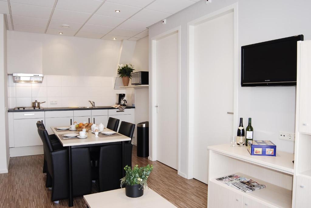 een keuken en eetkamer met een tafel en stoelen bij Kodde Apartments in Aagtekerke