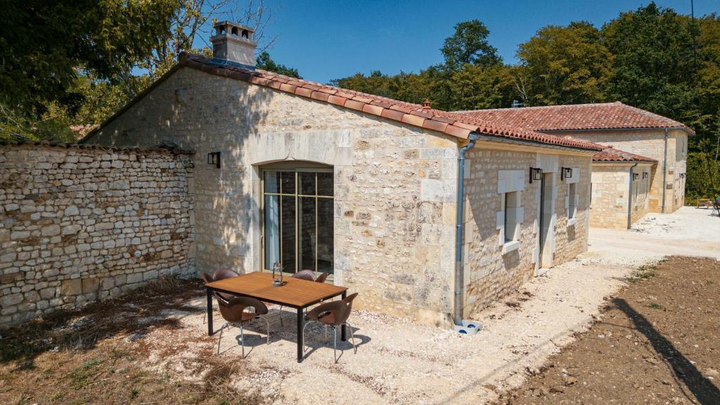 a small brick building with a table in front of it at La Châtellerie du Gagnon in Champagnolles