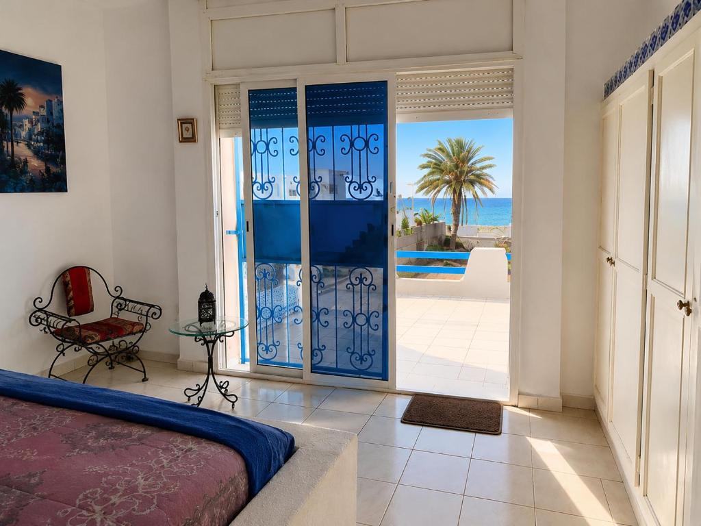 a bedroom with a bed and a view of the ocean at Villa Jasmin Zarzis in Zarzis