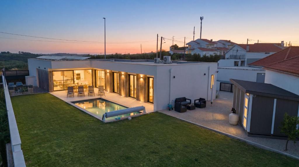 a house with a backyard with a swimming pool at Al Casa Branca in Lourinhã