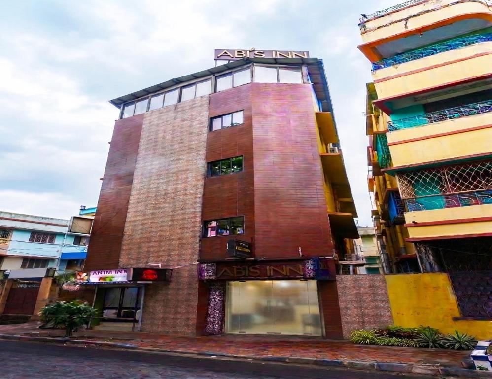 a tall red brick building with a sign on it at Abis Inn -Ballygunge in Kolkata