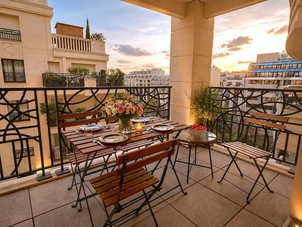 a balcony with a table and chairs on a balcony at Le Penthouse de Levallois in Levallois-Perret