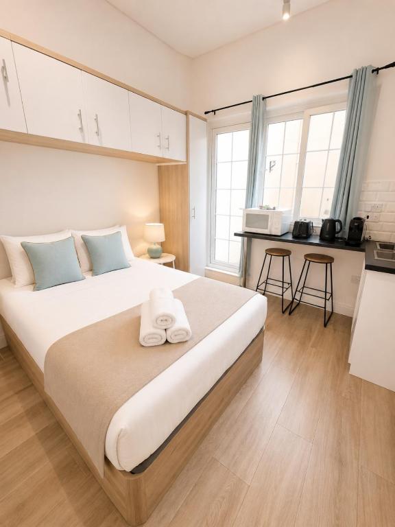 a bedroom with a large bed and a kitchen at Grand Central House - Classic Studio - GibraltarStay Apartments in Gibraltar