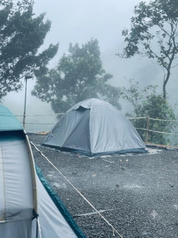 a tent sitting in a parking lot in the rain at Gandhara Tent camping in Vagamon
