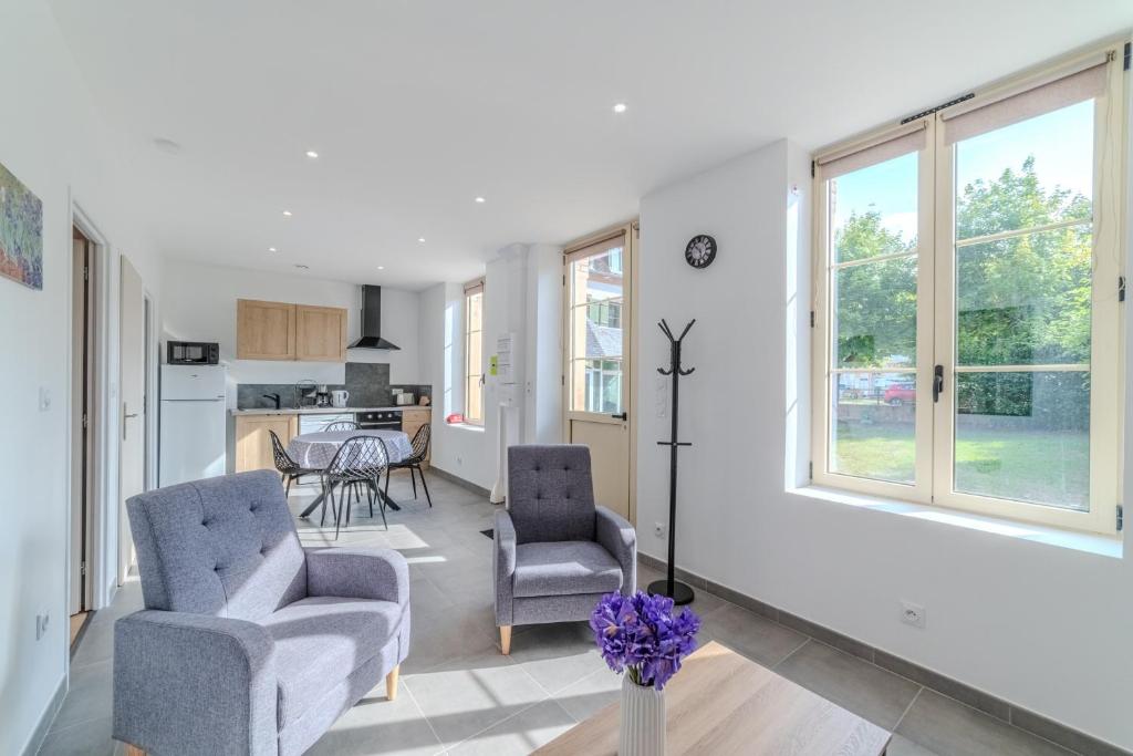 a living room with two chairs and a table at La Demeure des Sources - Iris - Avec climatisation in Bourbon-Lancy
