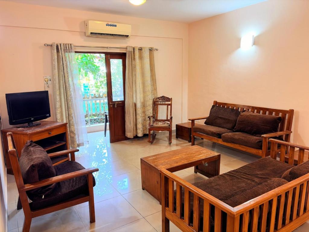 a living room with a couch and a tv at Siolim Serenity in Siolim