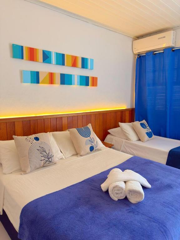 a bedroom with two beds with towels on them at Brothers Suites Centro Búzios in Búzios