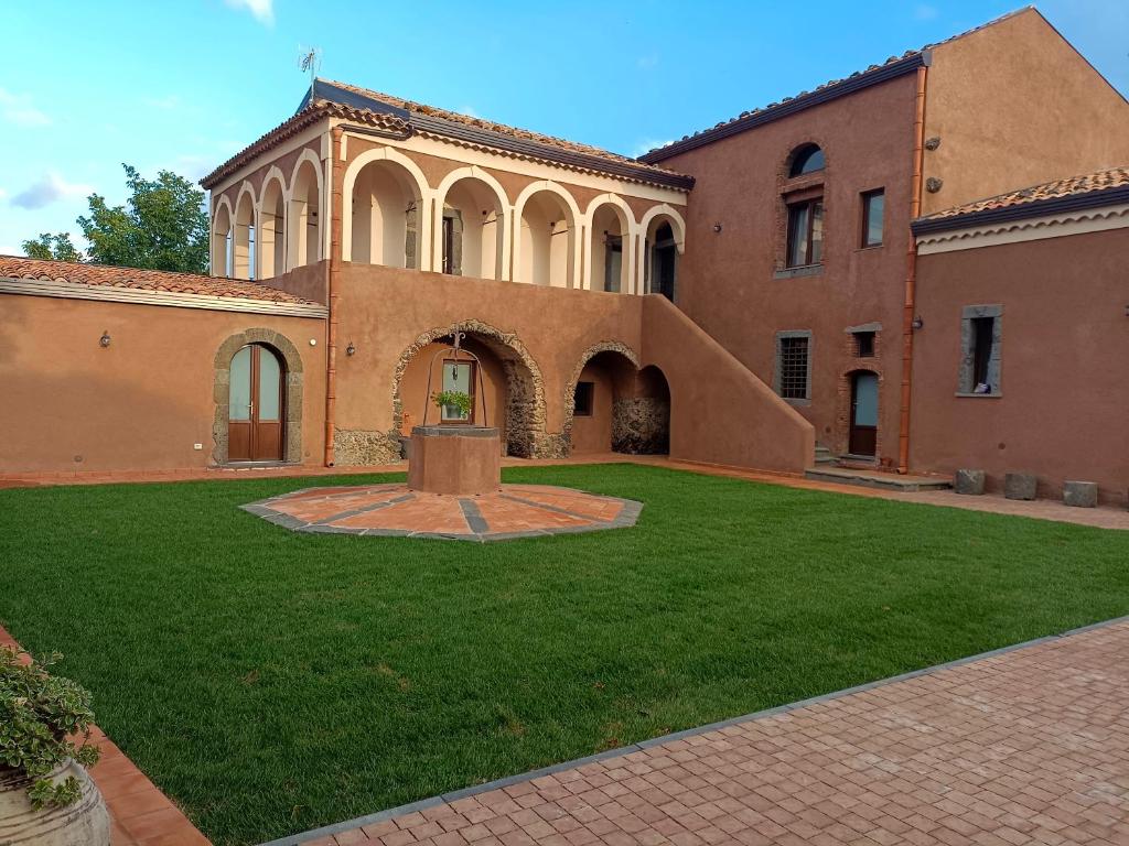 a large building with a green lawn in front of it at CASALE DILETTOSO Etna Relais in Randazzo