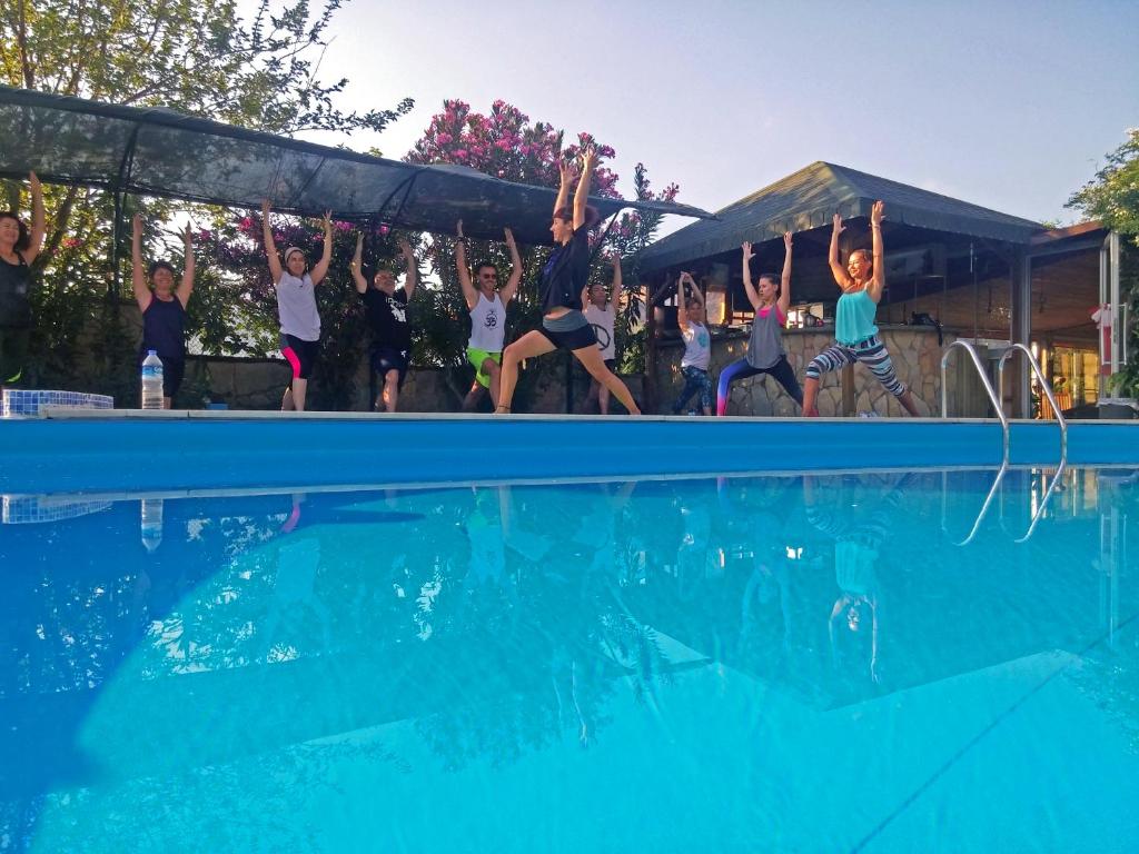 a group of people jumping into a swimming pool at Papirus Hotel in Adrasan