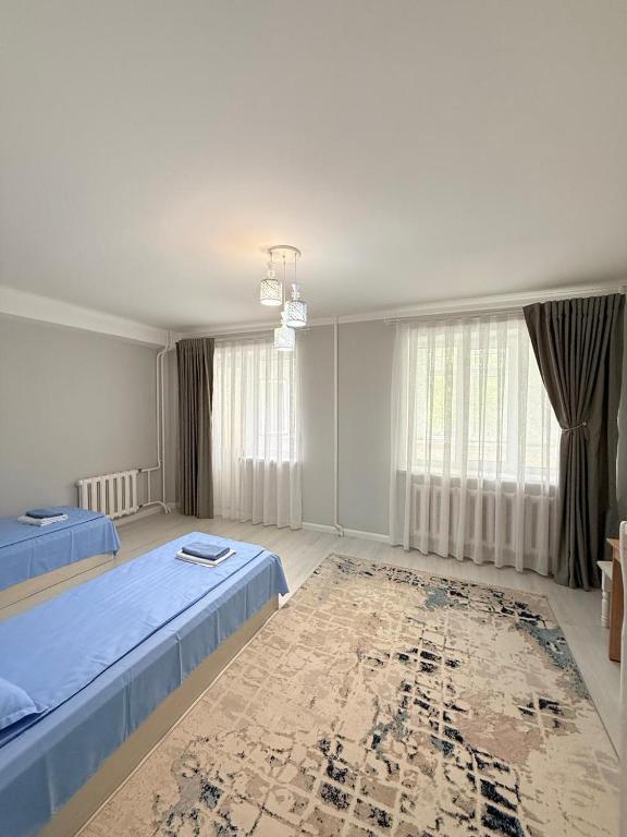 a bedroom with two beds and a rug at Jaily in Astana