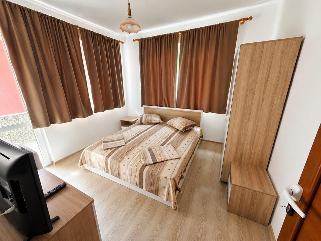 a bedroom with a bed and a desk and a television at Guest House Dayana Double Room 1 in Ravda
