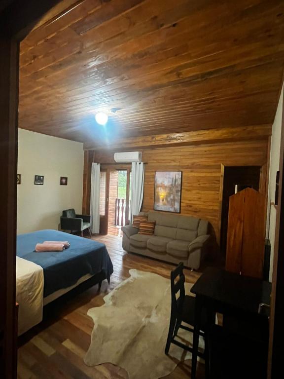 a bedroom with a bed and a couch in a room at Hotel Pirâmides Sagradas in Grão Pará