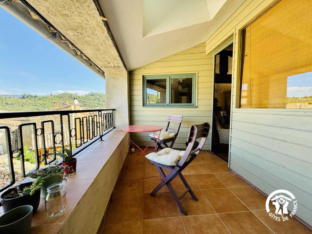 a balcony with two chairs and a table at Gîte de la jument rousse in Lagrasse