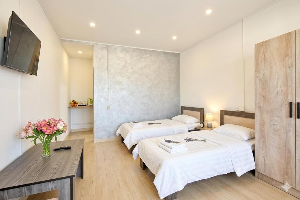 a hotel room with two beds and a television at Zvartnots in Zvartnots International Airport