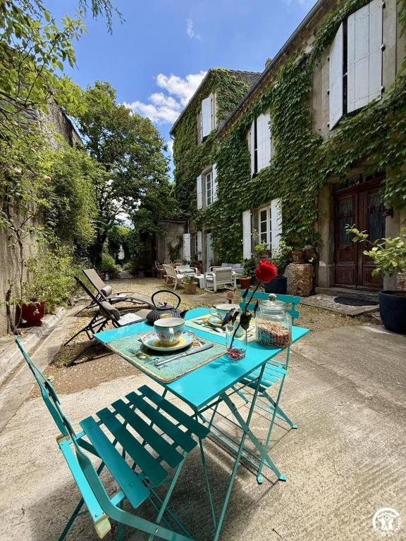 a blue table and chairs sitting in front of a house at La calade in Douzens
