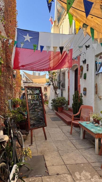 a sign in front of a house with an american flag at Jaguar Hostel in Viña del Mar