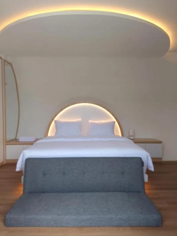 a bedroom with a large bed with a blue couch at Shira Villa in Seturan
