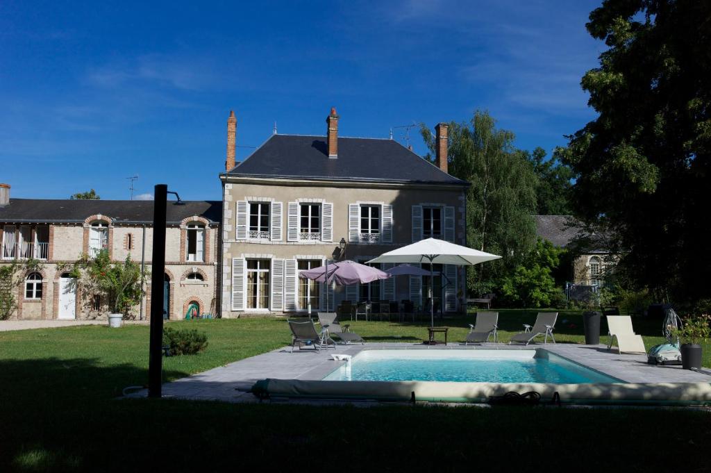 a large house with a swimming pool in front of it at Gite "Le Havre de Marie" in Lailly-en-Val