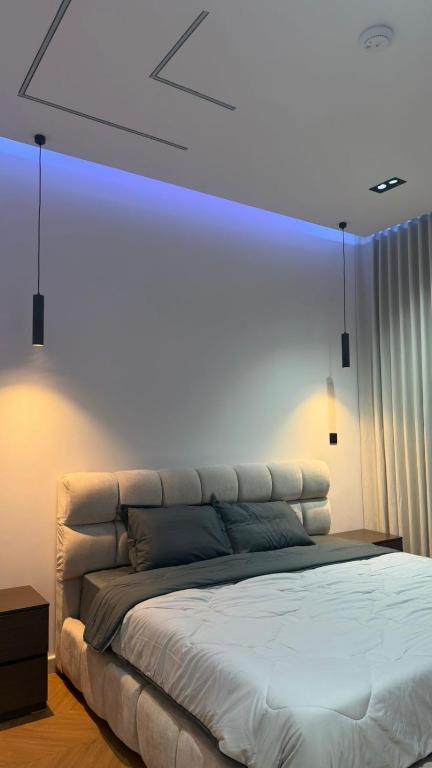 a bedroom with a bed with a blue light above it at استديو فندقي دخول ذكي عائلي مريح in Al Ahsa