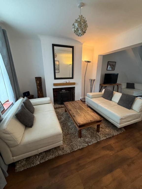 a living room with two white couches and a table at Stay at 48 in Oulton