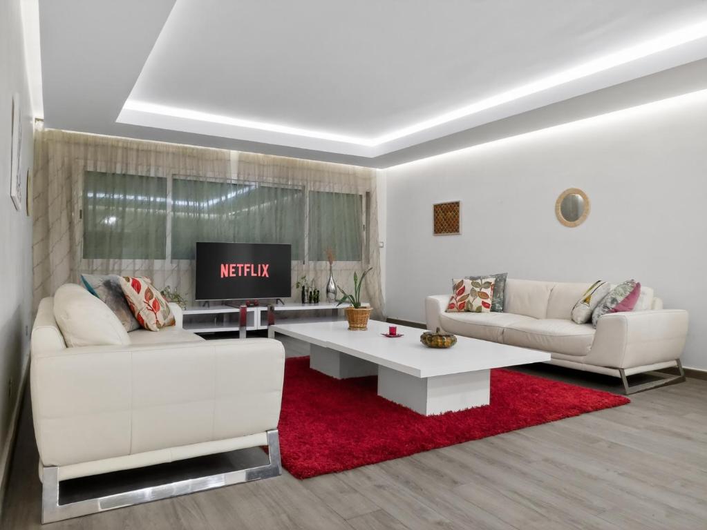 a living room with two white couches and a red rug at Atlas - Appartement moderne in Fez