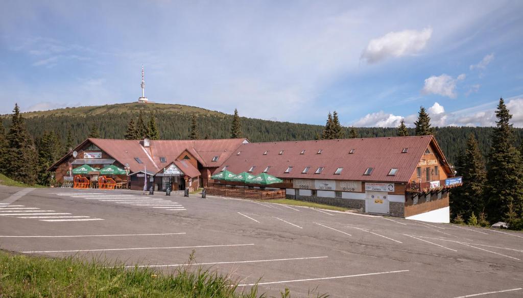 a large building with a parking lot in front of it at Horská Chata Sabinka in Malá Morávka