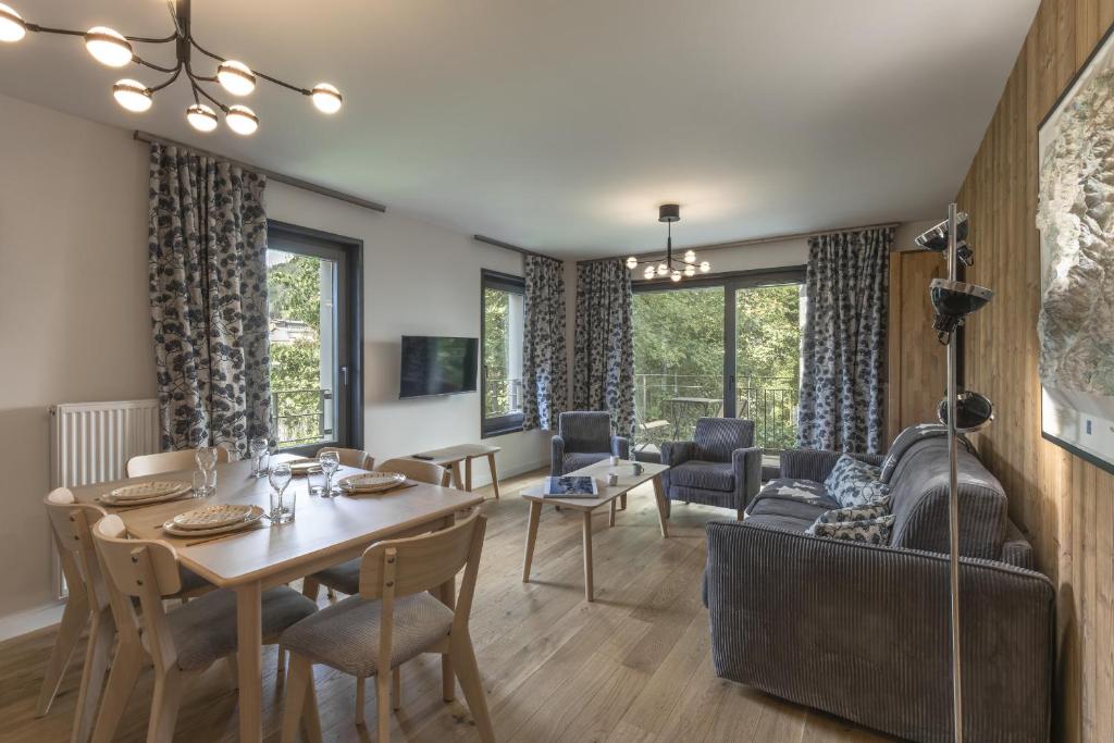a living room with a table and a dining room at Canopee 206 - by Care Concierge in Saint-Gervais-les-Bains