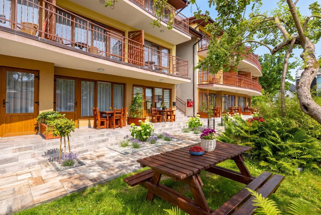 an image of a house with a picnic table in the yard at Dom Wczasowy Radość in Rewal