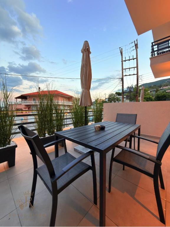 a wooden table and two chairs on a patio at Royal Vinea Suites in Elevtheraí