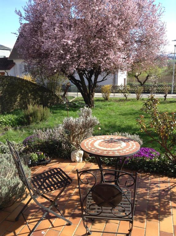 a table and chairs on a patio with a tree at Terassenwohnung in Starzach