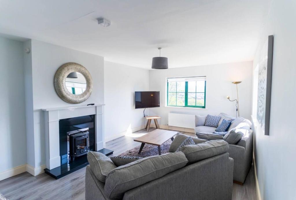 a living room with a couch and a fireplace at Old Rectory House - Waterville in Waterville