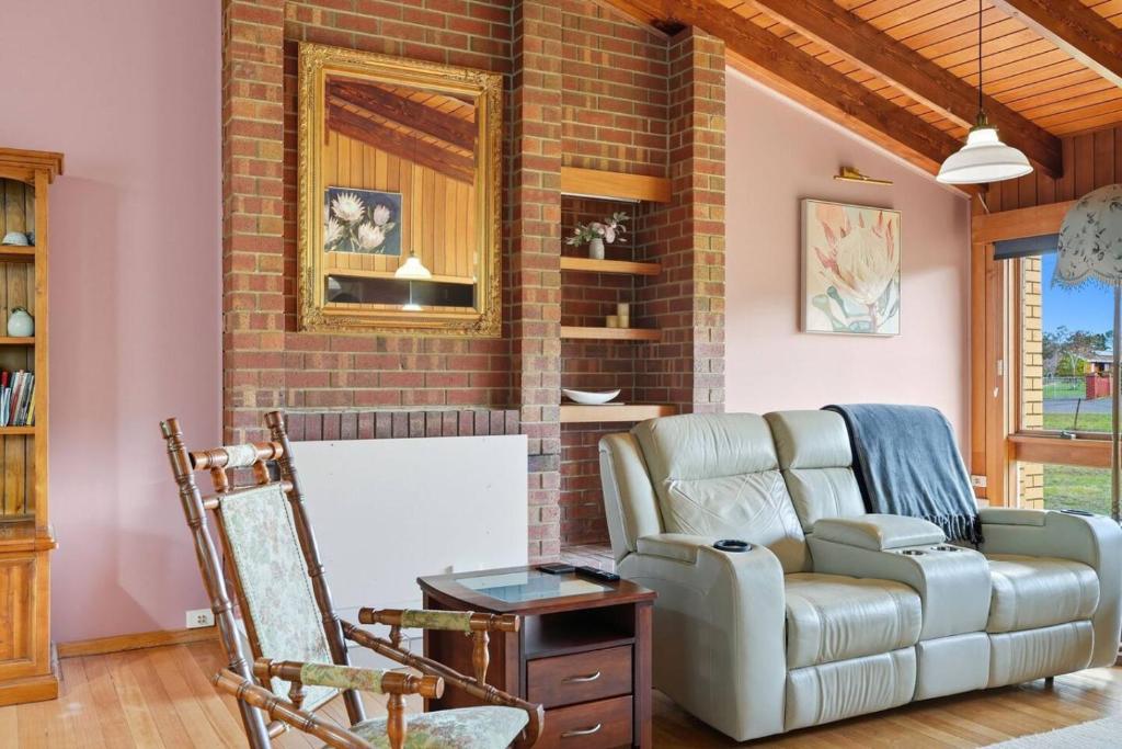 a living room with a couch and a chair at Wildlife, Waves Getaway in Acton Park