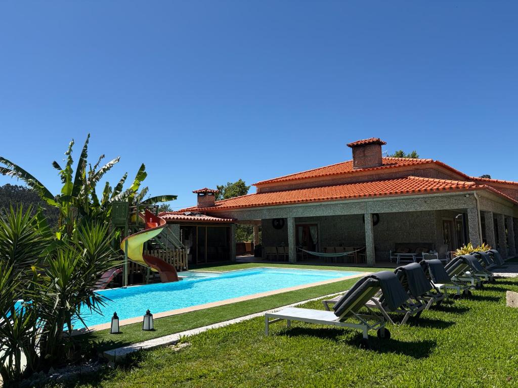 a house with a swimming pool with a slide at Villa Bessa Nature & Spa in Fafe