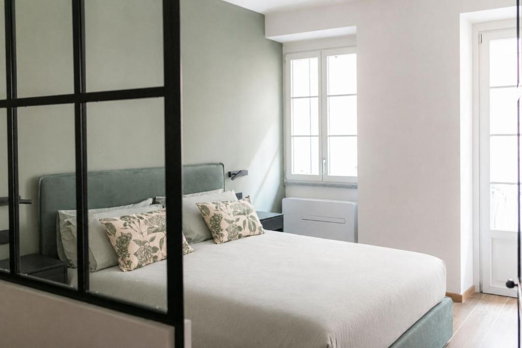 a bedroom with a white bed with a mirror at Casa Botanica - Boutique Apartment nel centro di Alba in Alba
