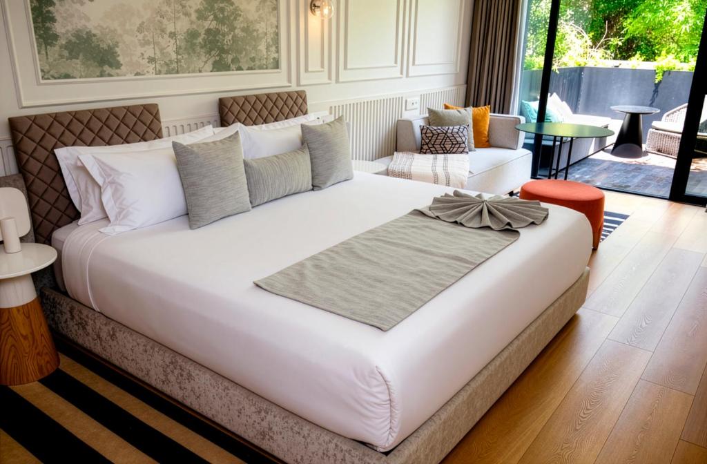 a large white bed in a room with a couch at Oliver Mexico City in Mexico City