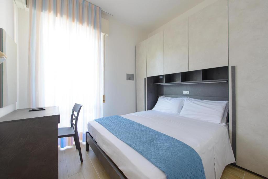 a bed in a room with a desk and a bed sidx sidx sidx at Hotel Colorado in Rimini