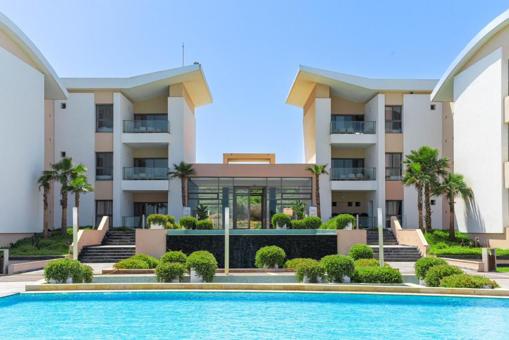 a building with a swimming pool in front of a building at Zephyr Mazagan in El Jadida