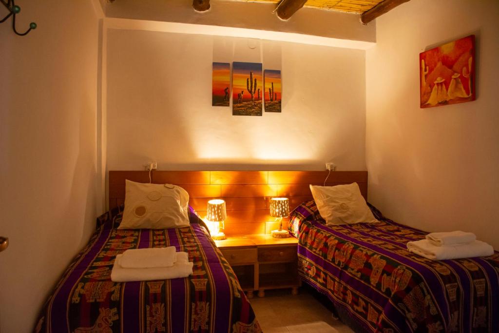 a room with two beds and a desk in it at Luna Victoria - apart in Purmamarca